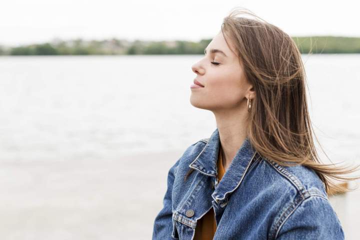 side view woman enjoying sea breeze